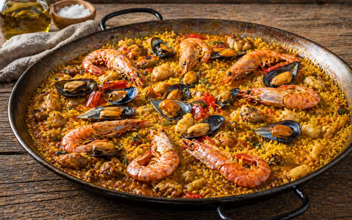 Paella mixta met kip, garnalen, mosselen en inktvis in paella pan