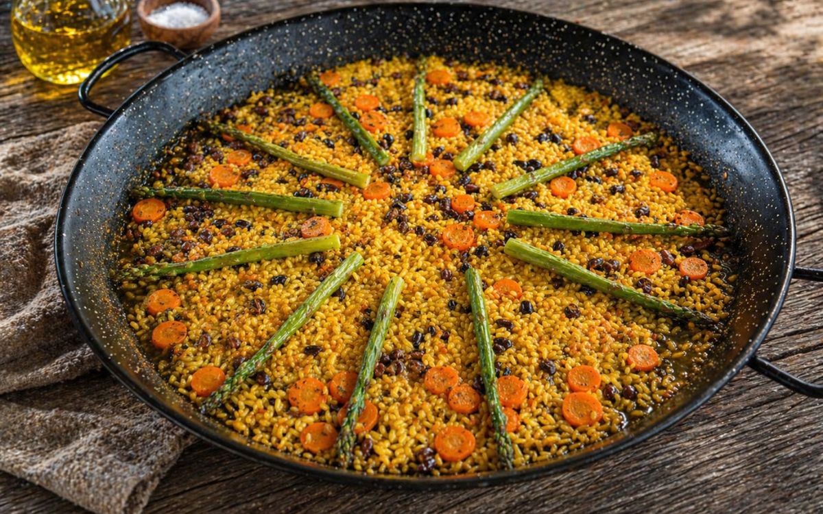 Vegetarische paella met groene asperges, wortel en bonen in een traditionele paella pan